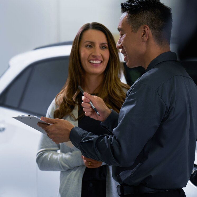 Asesor de ventas atendiendo a una clienta en una concesionaria